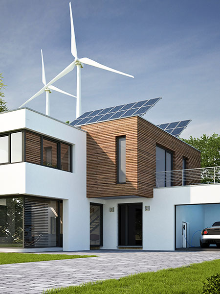 Modernes Haus mit PV-Anlage auf dem Dach; Windräder im Hintergrund